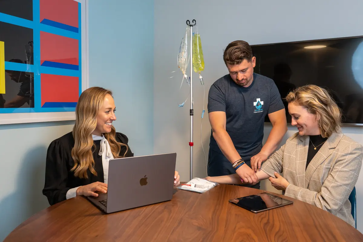 An Intravene registered nurse starting an IV drip for a client on a mobile visit