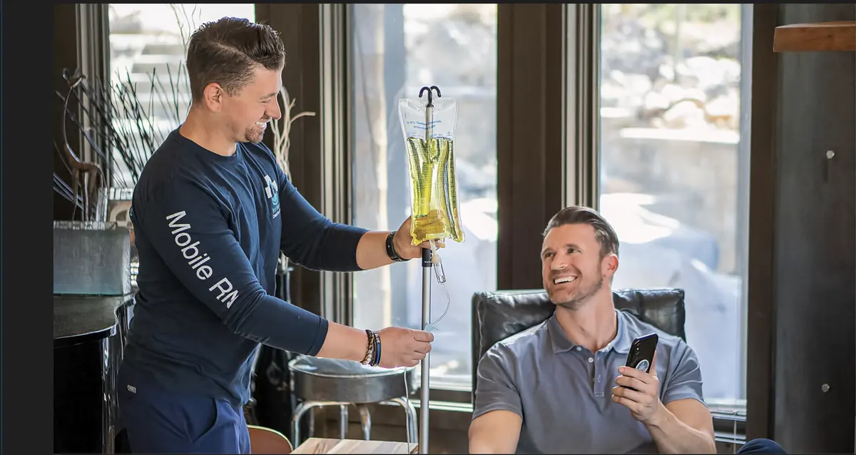 A mobile nurse hanging an IV drip for a client in their living room